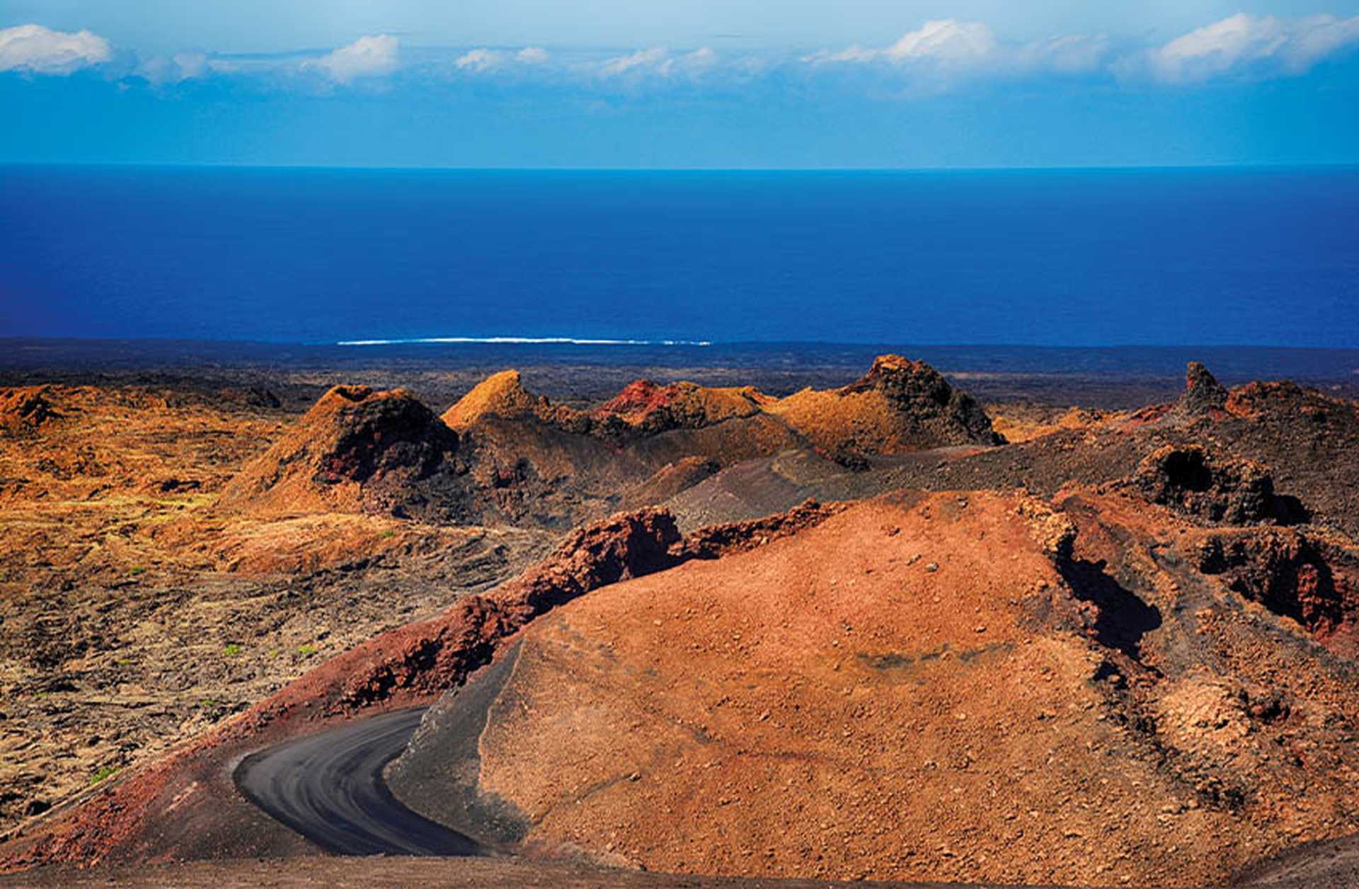 Red volcanic rocks lead to the Atlantic Ocean in Timanfaya National Park, Lanzarote