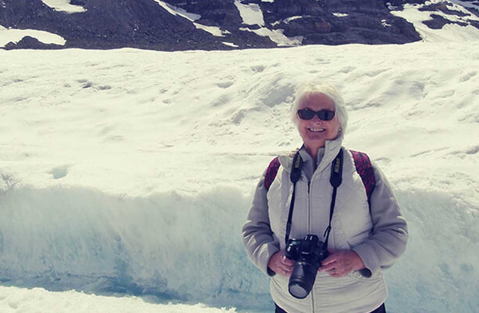 Titan traveller Susan poses in front of snowy mountains