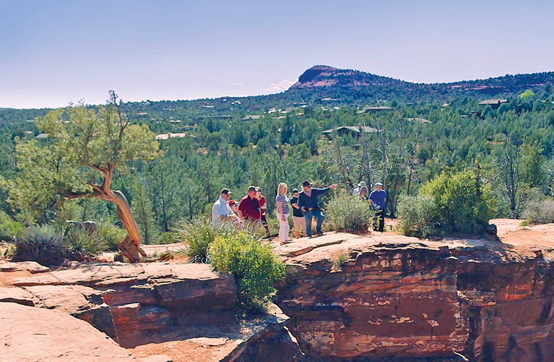 A tour guide points out sites of interest to a group in a National Park, USA
