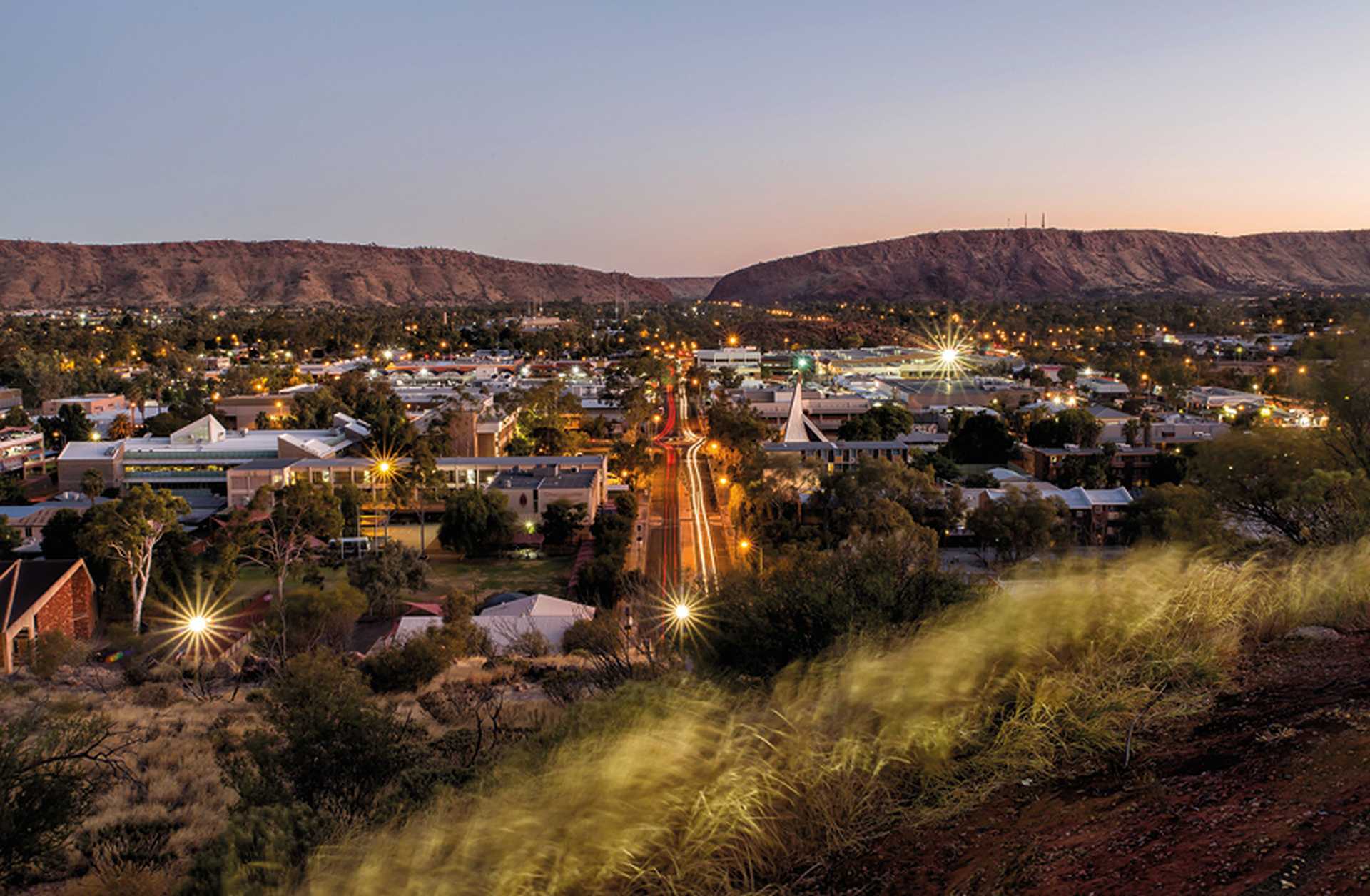 Alice Springs at sunset, with mountains in the background. Visit on one of Titan's Australia tours