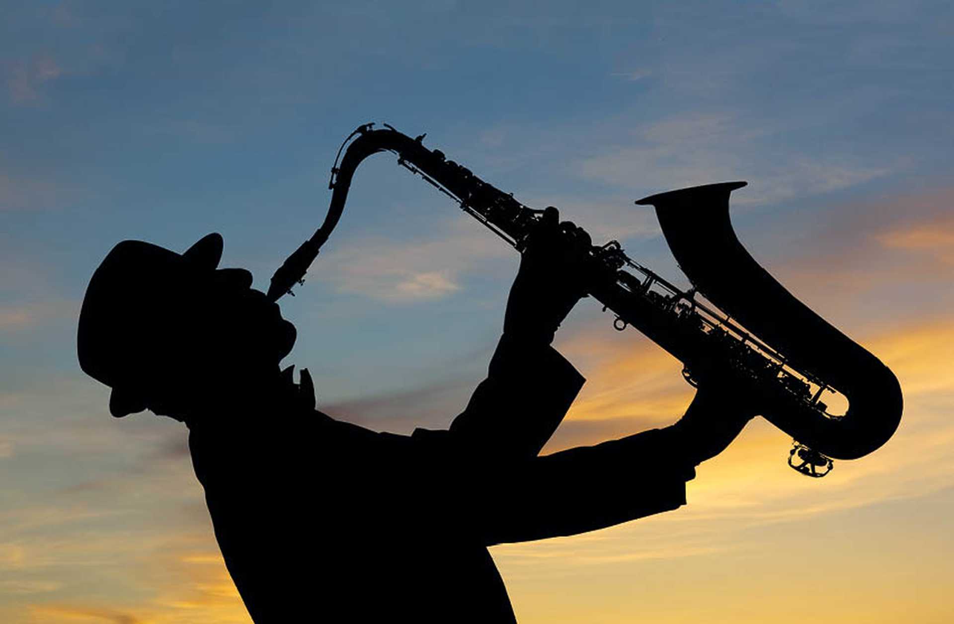 Silhouette of a man playing a saxophone
