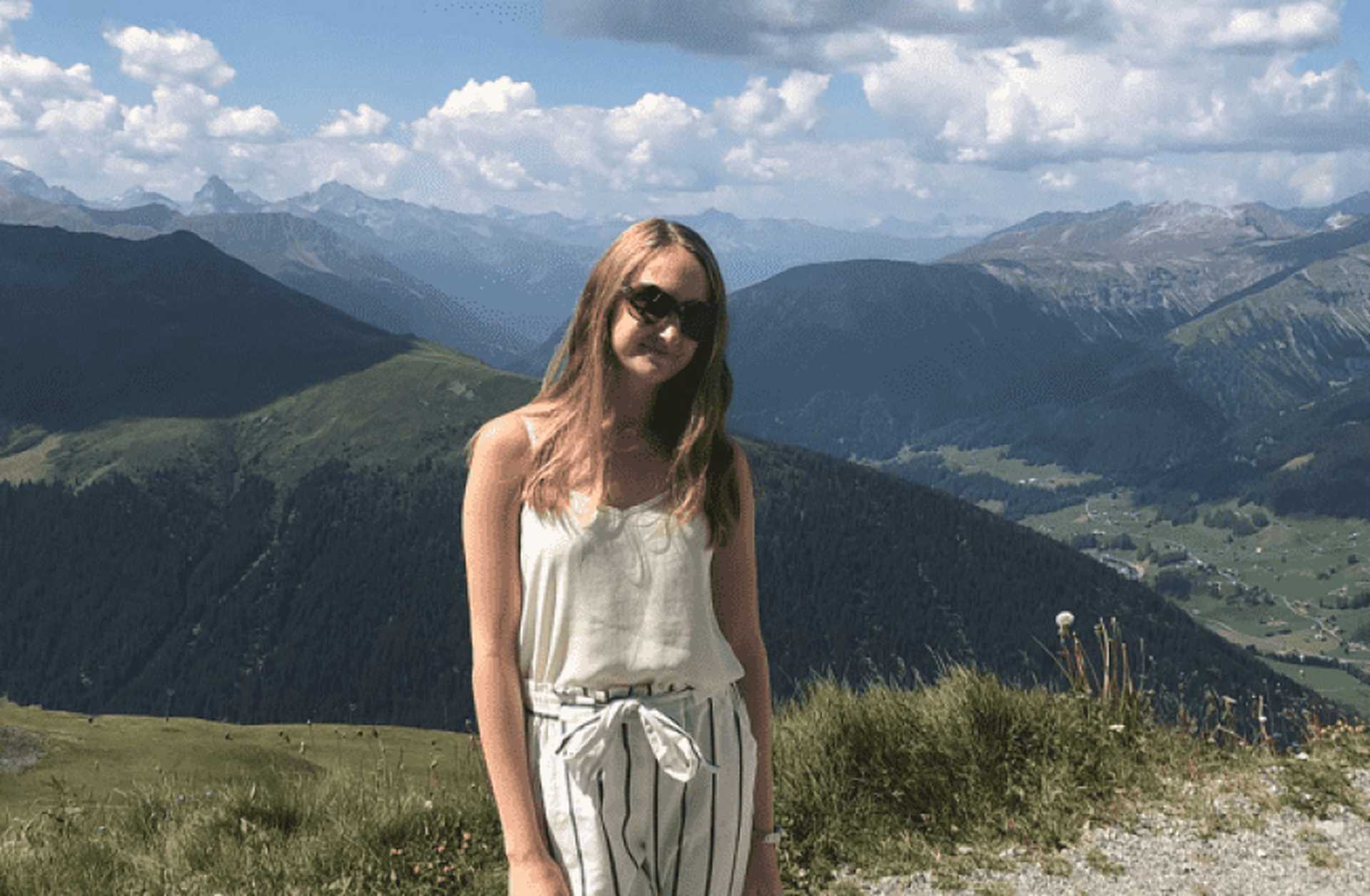 Harriet poses in front of a spectacular mountain view in Switzerland