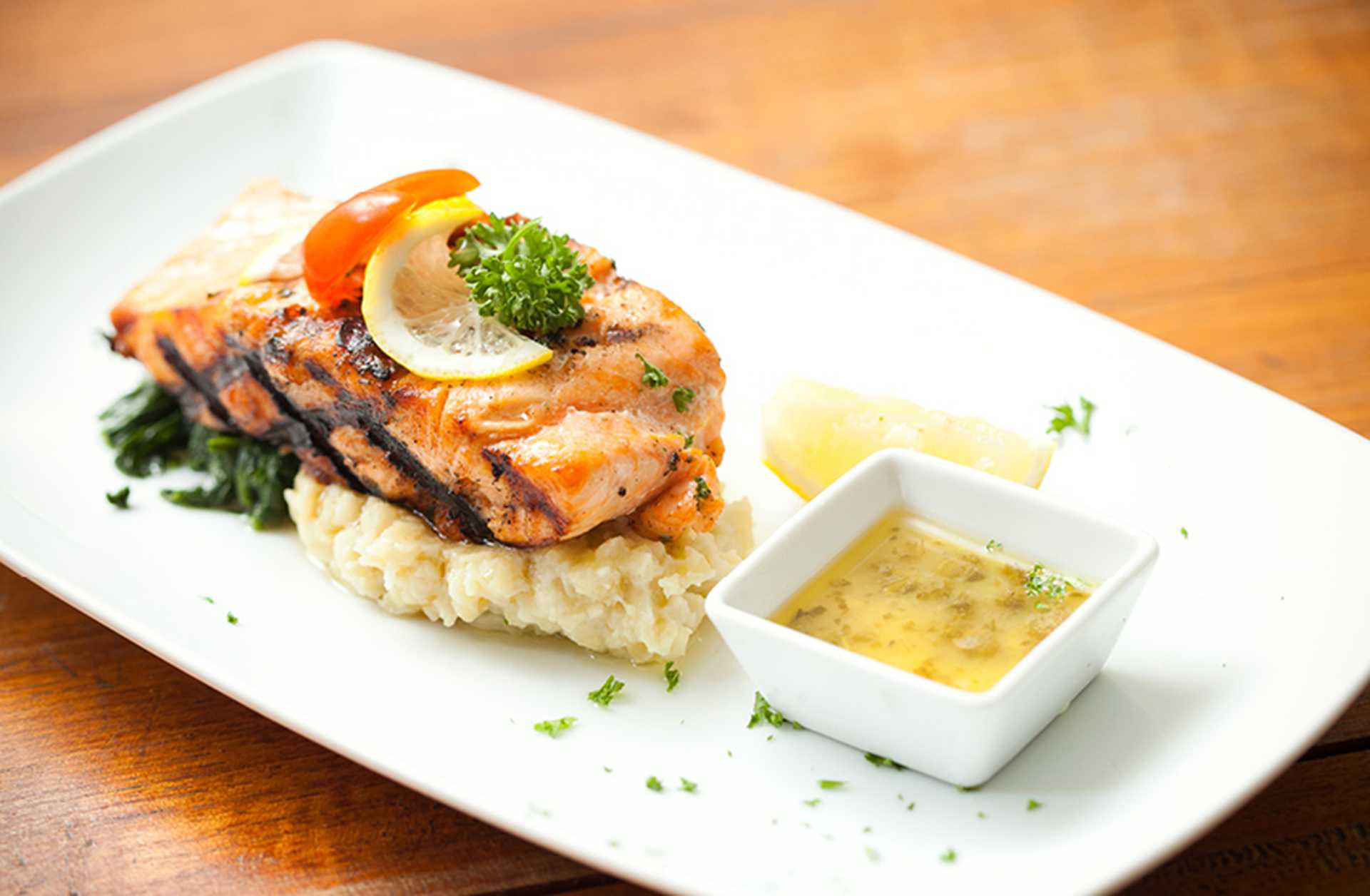 Norwegian salmon steak and mashed potato is served on a white dish