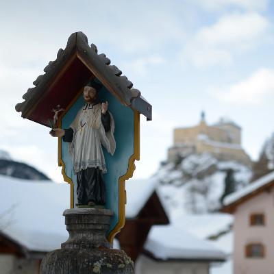 Kleine Statur mit verschwommener, schneebedeckter Stadt im Hintergrund
