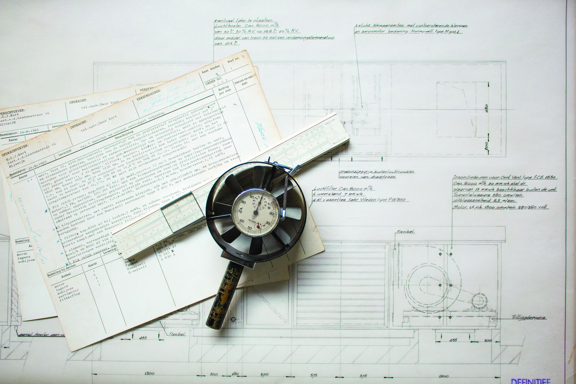 Photograph of blueprints and a oldschool pressure gauge