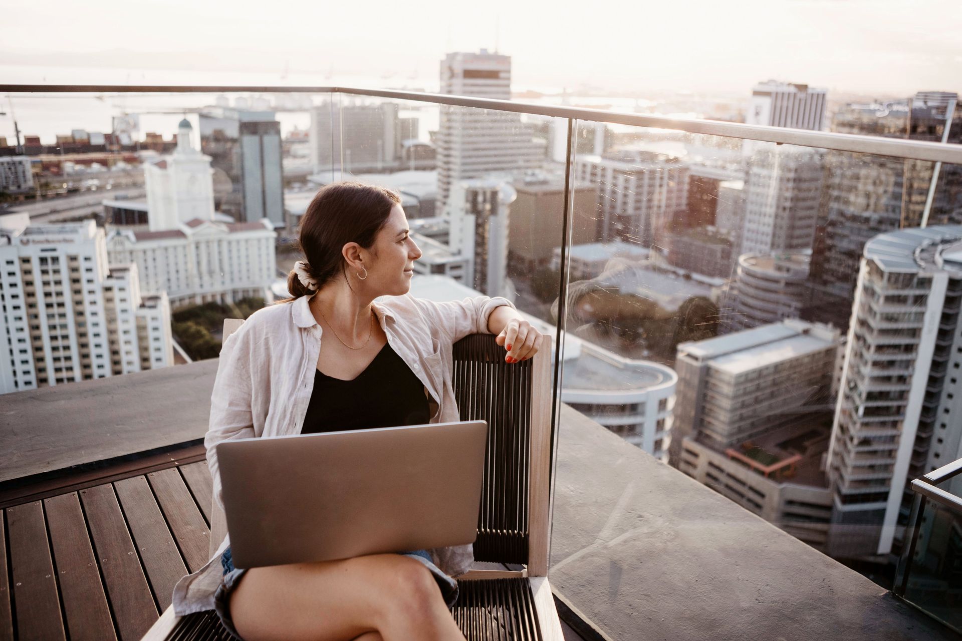 Photograph of a woman sitting on a rooftop