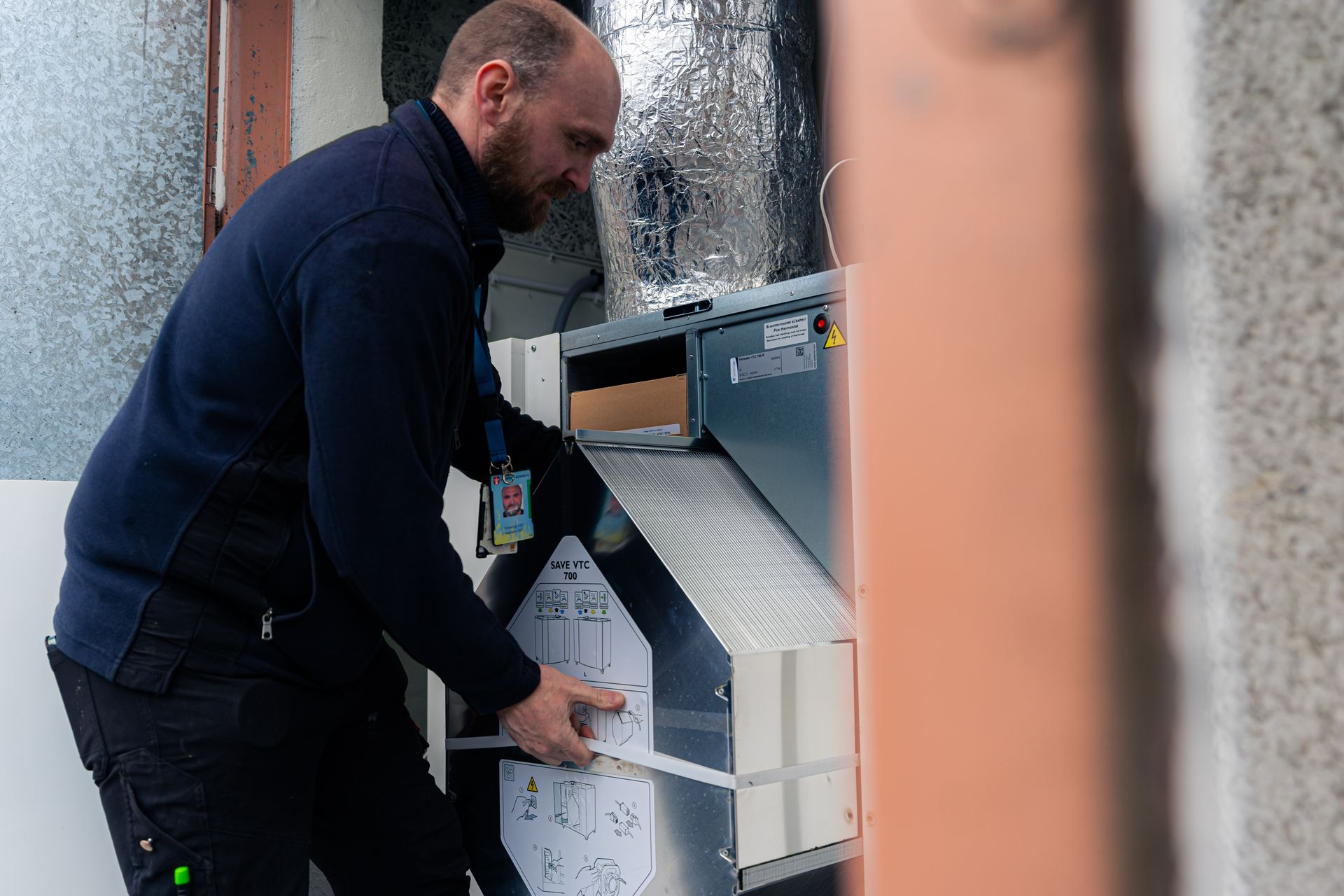 Photograph of a man installing a Systemair product in a residential