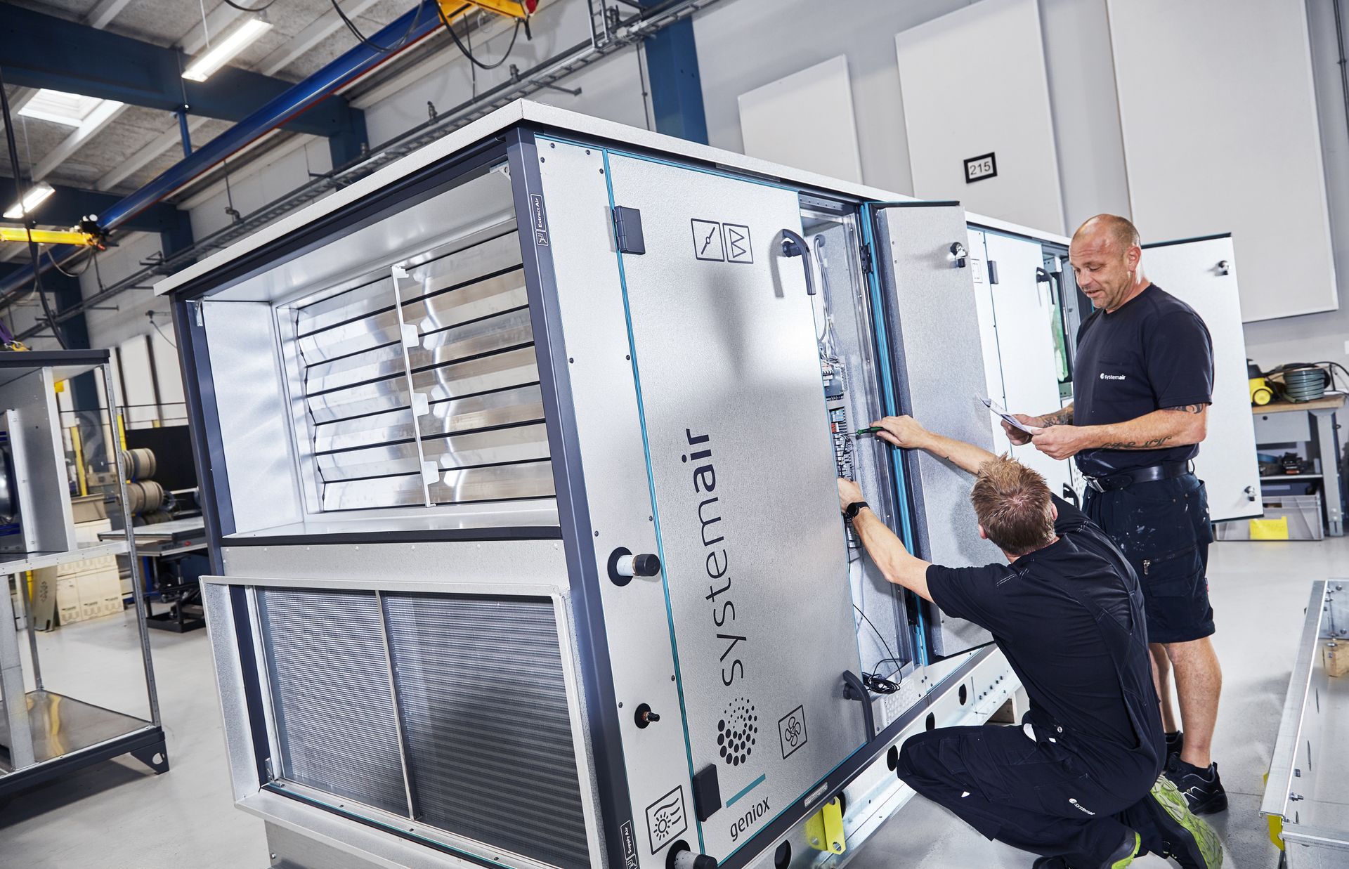 Two people working on a Geniox unit