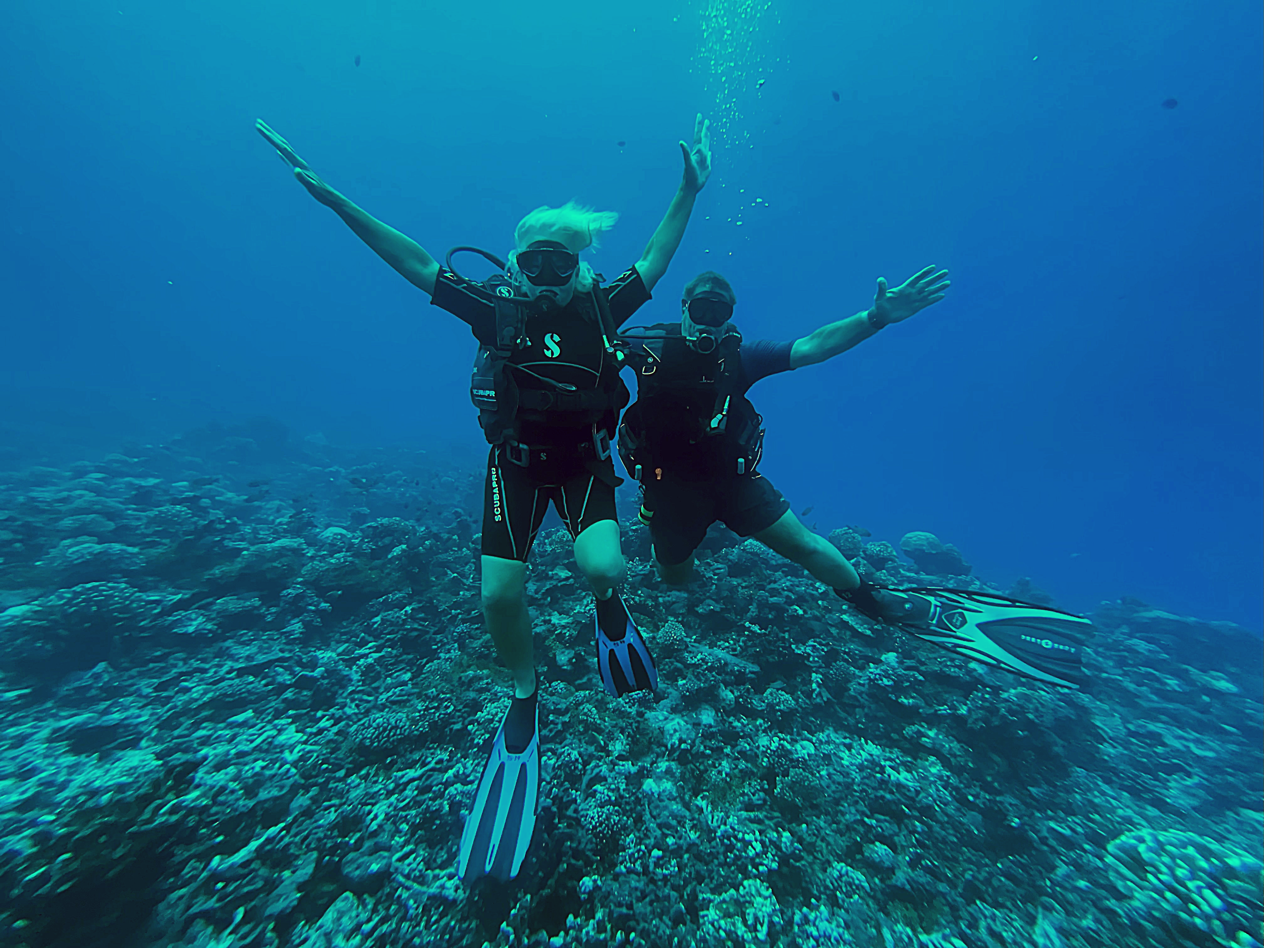 Underwater photo of Jane and Walt celebrating that Jane passed her PADI open water scuba training