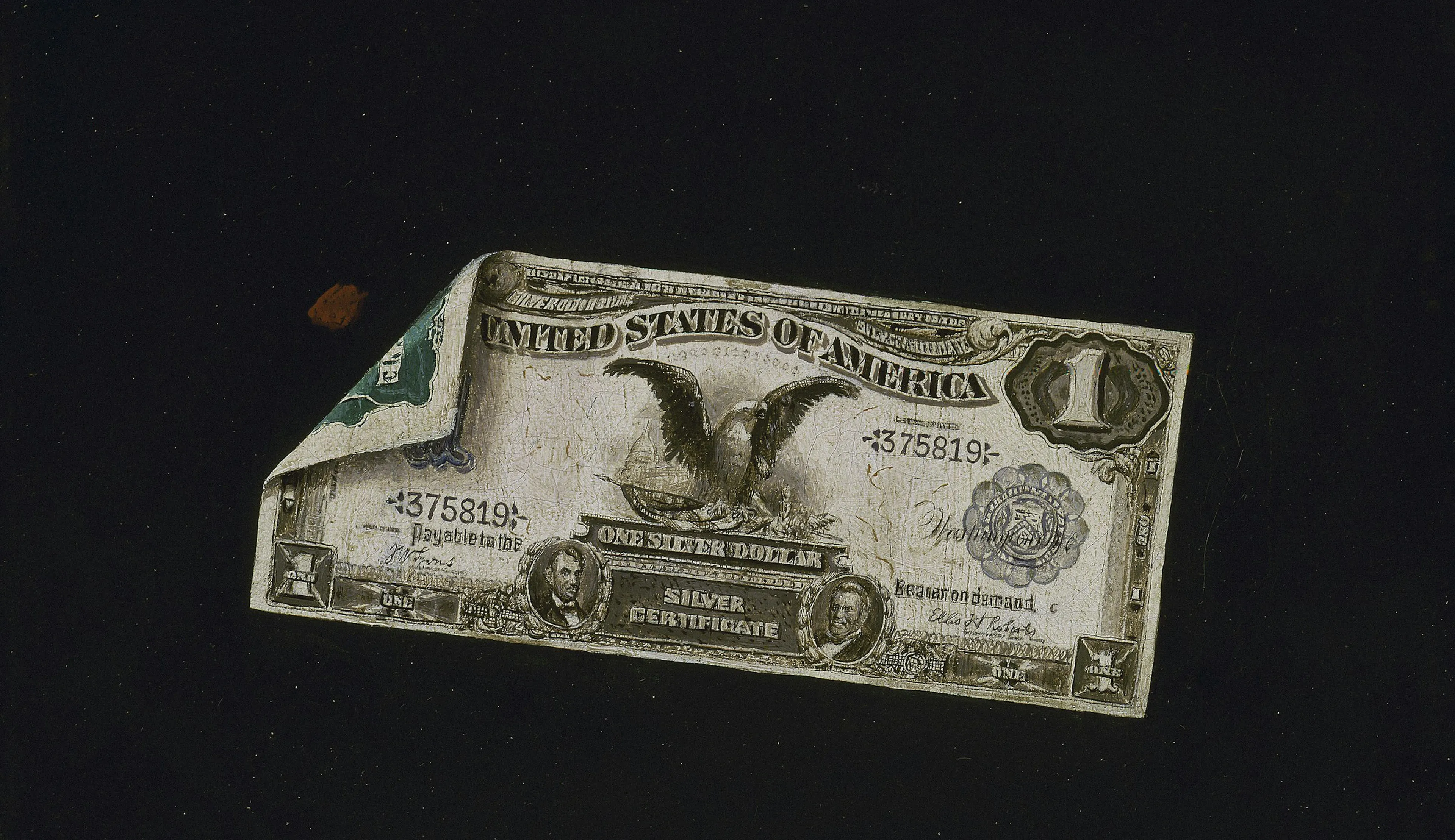 A worn, vintage U.S. silver certificate with an eagle design and a visible crease, set against a dark background.