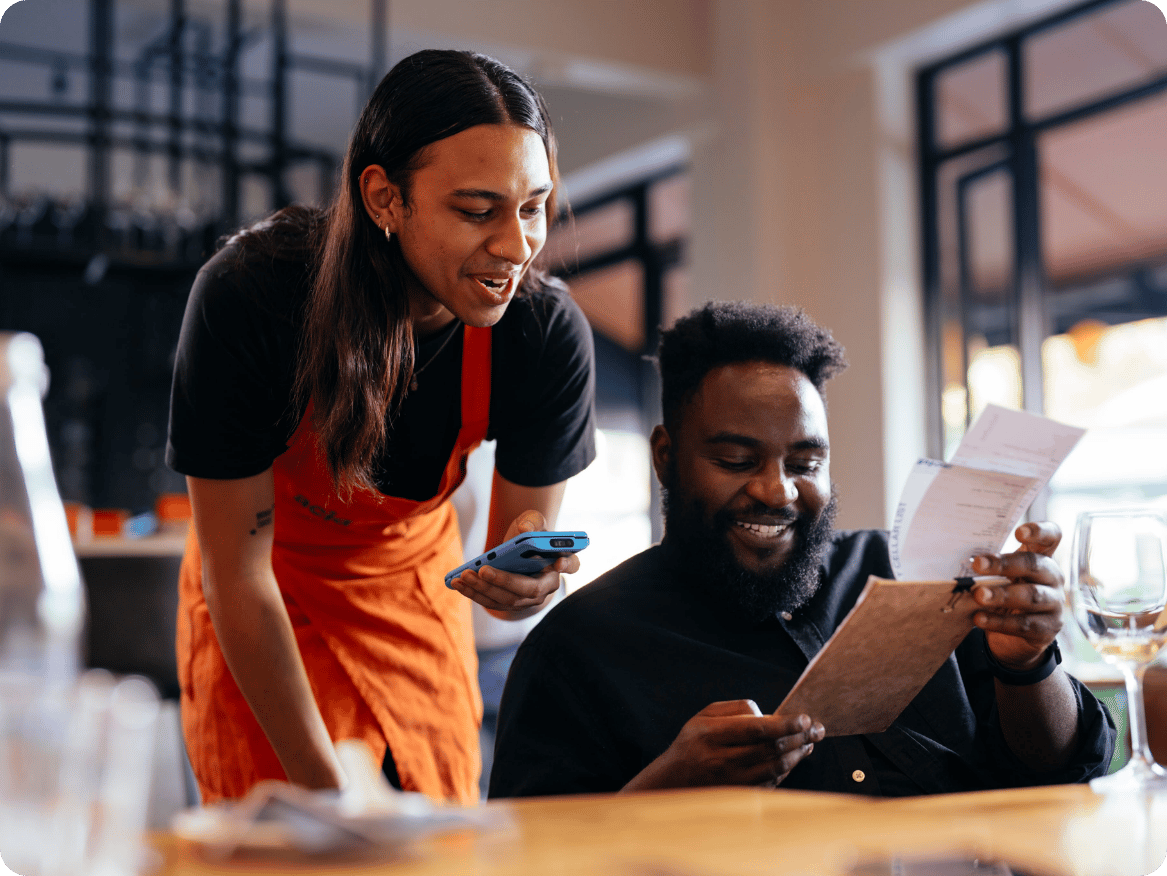 Restaurant server taking a customer’s order with a handheld point of sale device