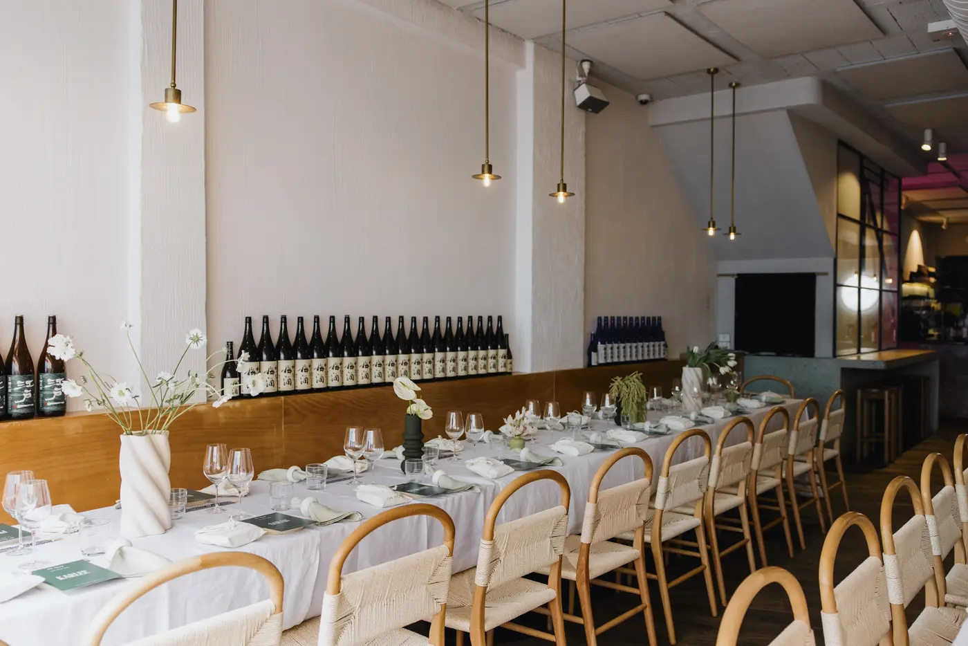 The Backroom’s long dressed table, cane chairs, white walls and pendant lights