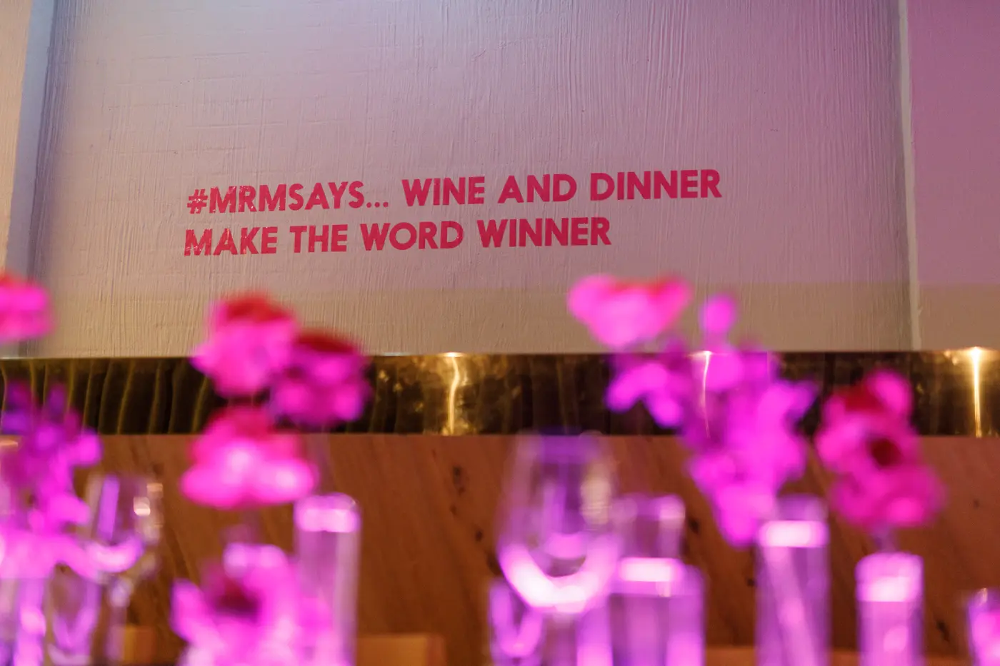 Pink flowers beneath a playful Mr. Miyagi slogan on the wall