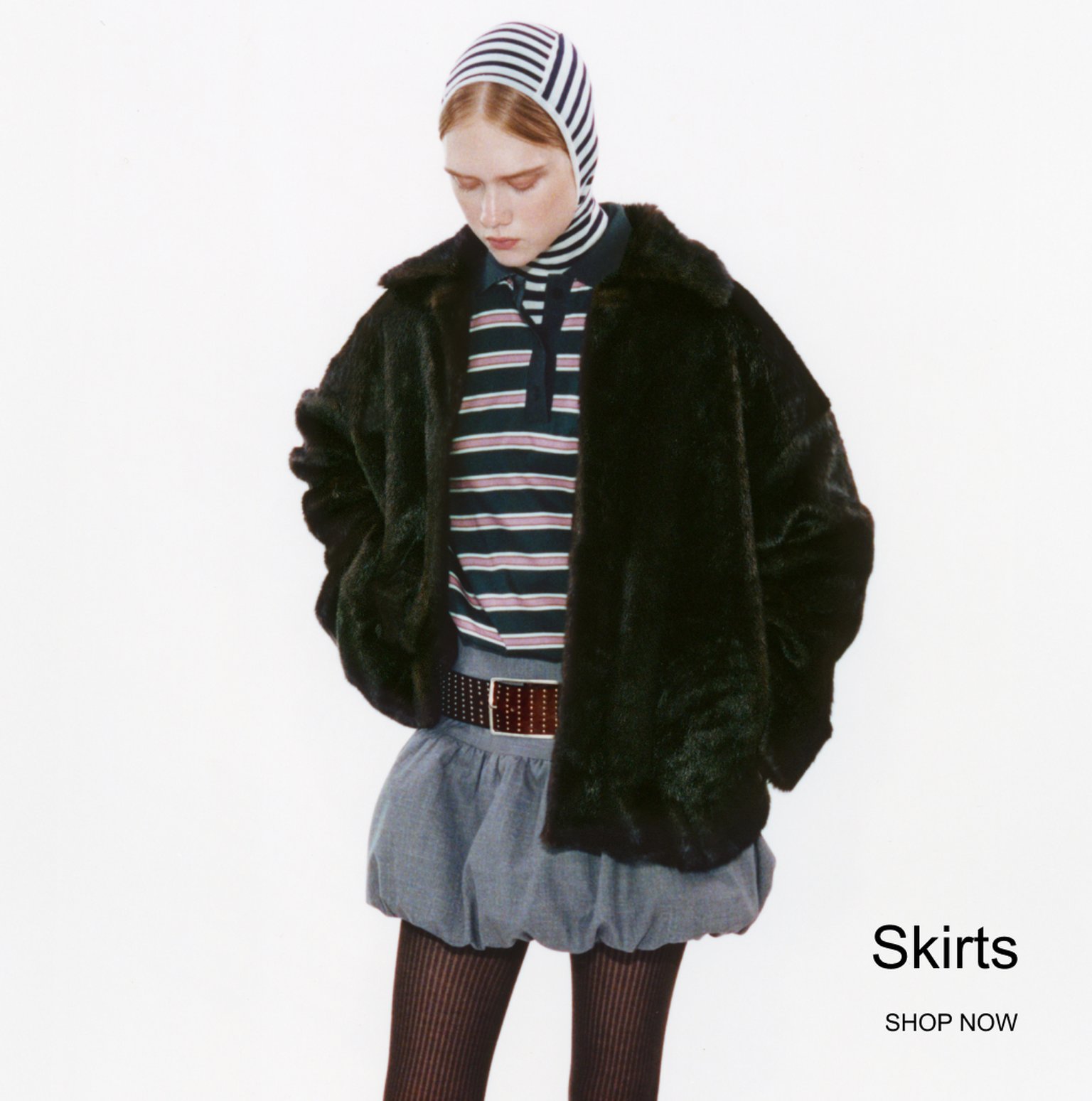 Woman in a striped shirt and fur jacket, wearing a striped headscarf, short skirt, and tights. Text: "Skirts, Shop Now."