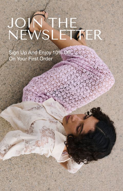 Woman in lace clothing sits on the ground, looking away. Text: "Join the Newsletter" with a 10% off offer.