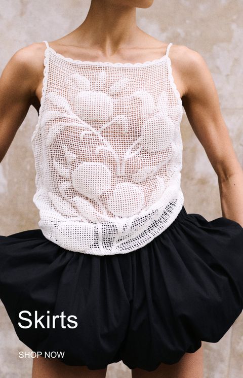 Model wearing a white crochet top and a black skirt with the text "Skirts, Shop Now" in the corner.