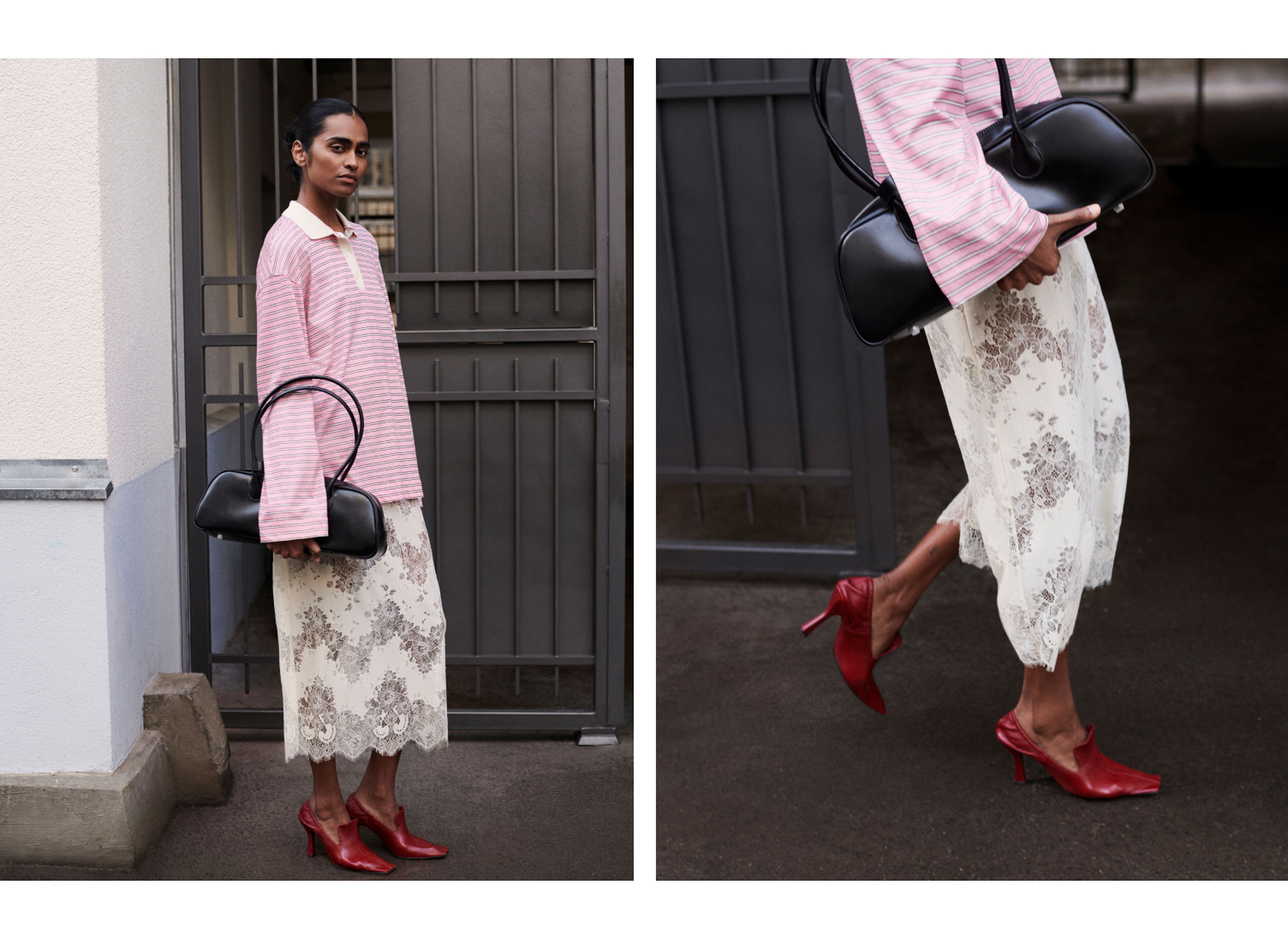 A woman in a pink striped shirt and lace skirt, holding a black handbag, wearing red heels, standing by a metal gate.
