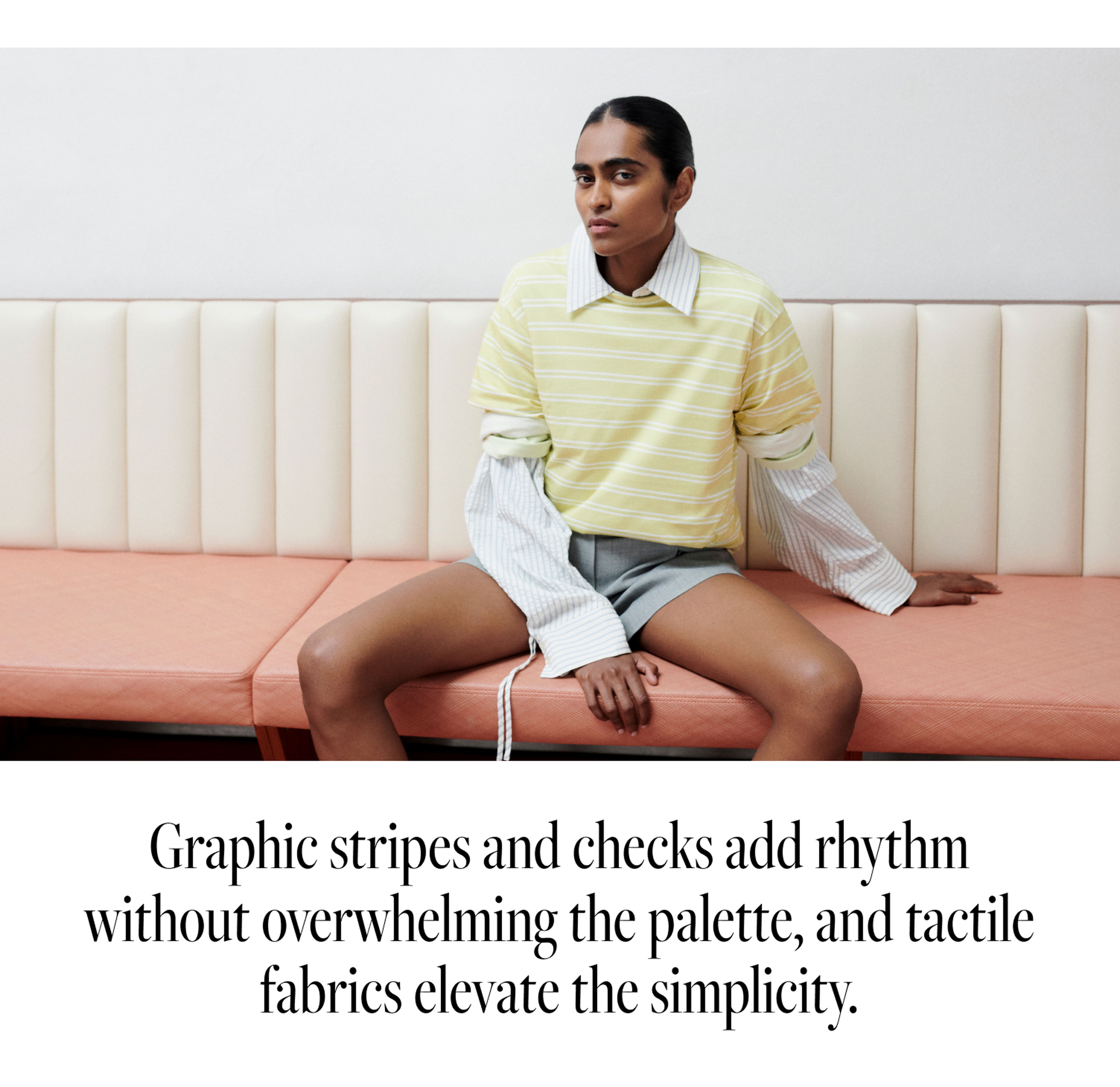 A person in a layered outfit with a yellow striped top and gray shorts sits on a peach bench in a minimalistic setting. Text below describes the styles.