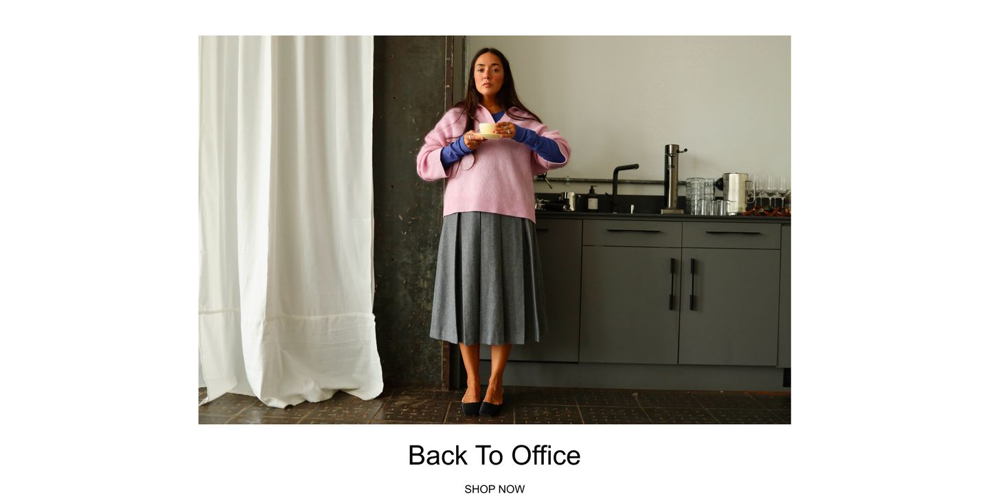 Woman in a pink sweater and gray skirt holds a cup, standing in a kitchen area with a sink and glasses. Caption reads "Back To Office, Shop Now."