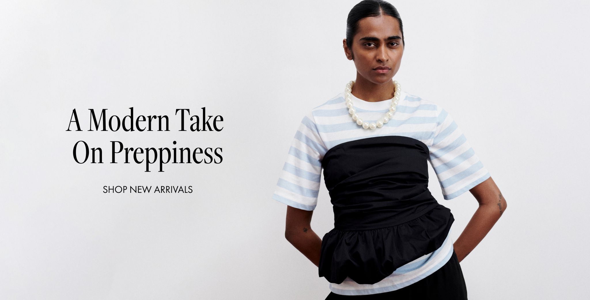 Model in striped shirt and ruched black top, wearing a pearl necklace. Text reads "A Modern Take On Preppiness. Shop New Arrivals."