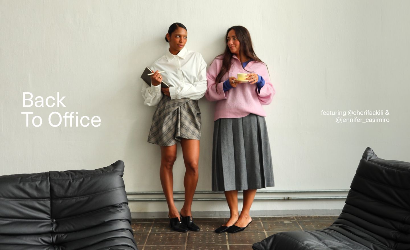 Two women in stylish office attire stand against a white wall, one holding a notebook and pen, the other a cup. Text reads "Back To Office."