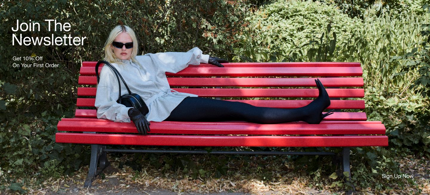 A person in sunglasses and stylish attire lounges on a red park bench, promoting a newsletter sign-up with a 10% discount offer.