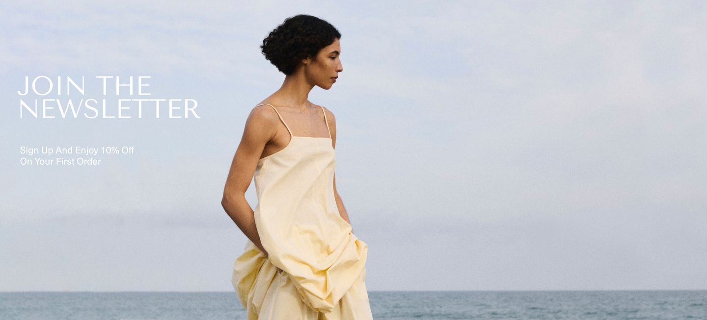 Woman in a flowing yellow dress by the sea with text promoting a newsletter sign-up for 10% off first order.