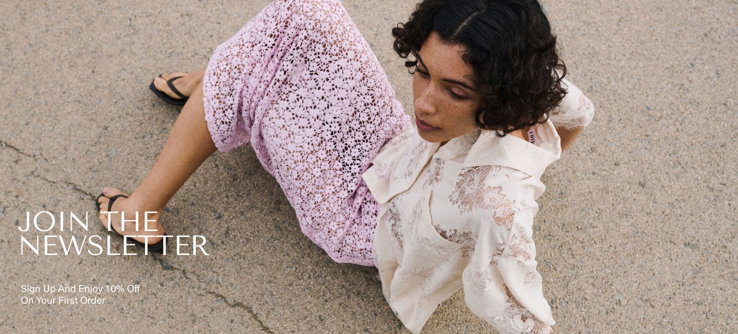 Woman in lace clothing sits on the ground, looking away. Text: "Join the Newsletter" with a 10% off offer.