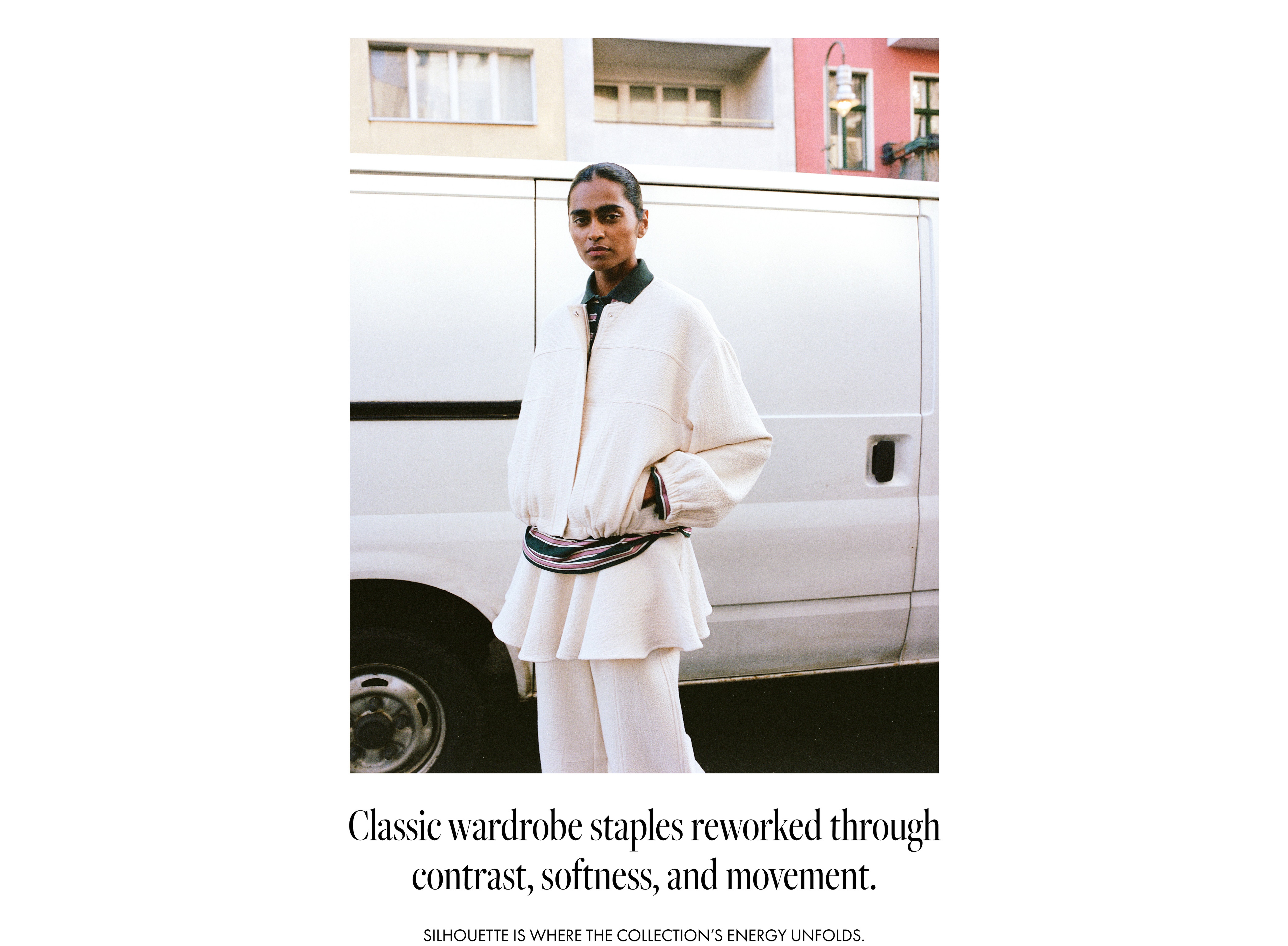 A person in a stylish white outfit stands by a van, with text about classic wardrobe staples below.