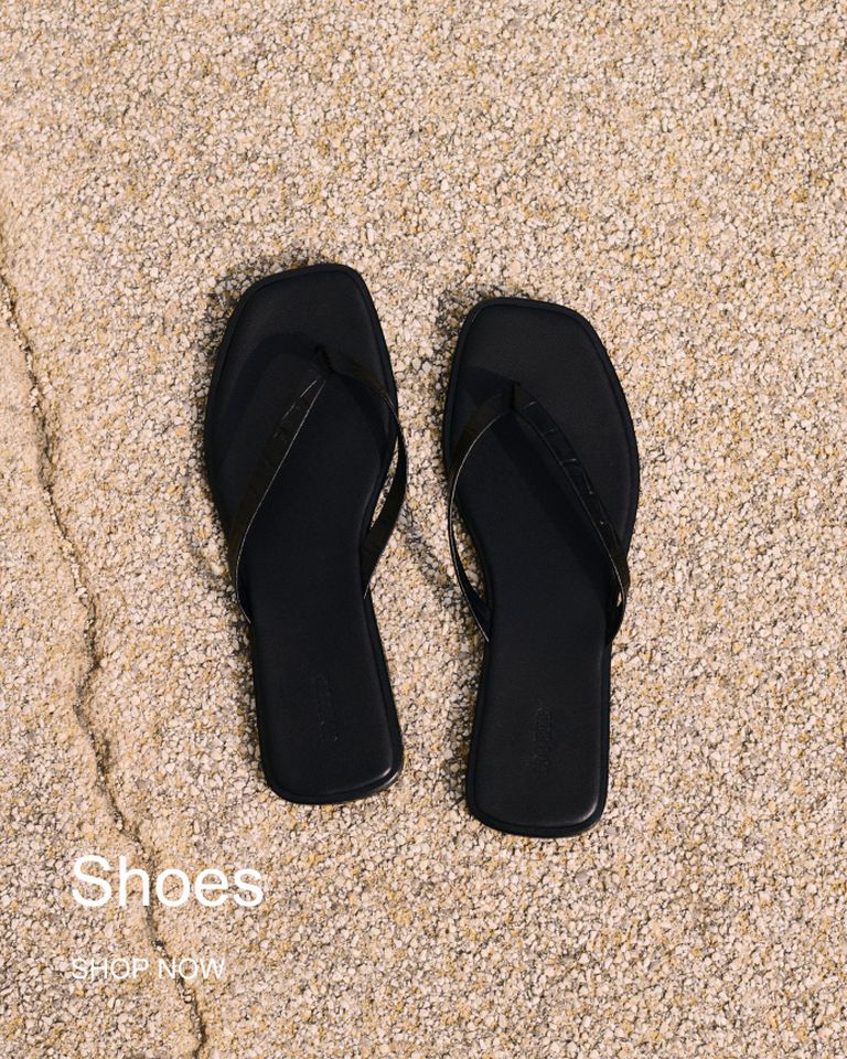 Black square-toed flip-flops on textured ground with "Shoes" and "Shop Now" text overlay.