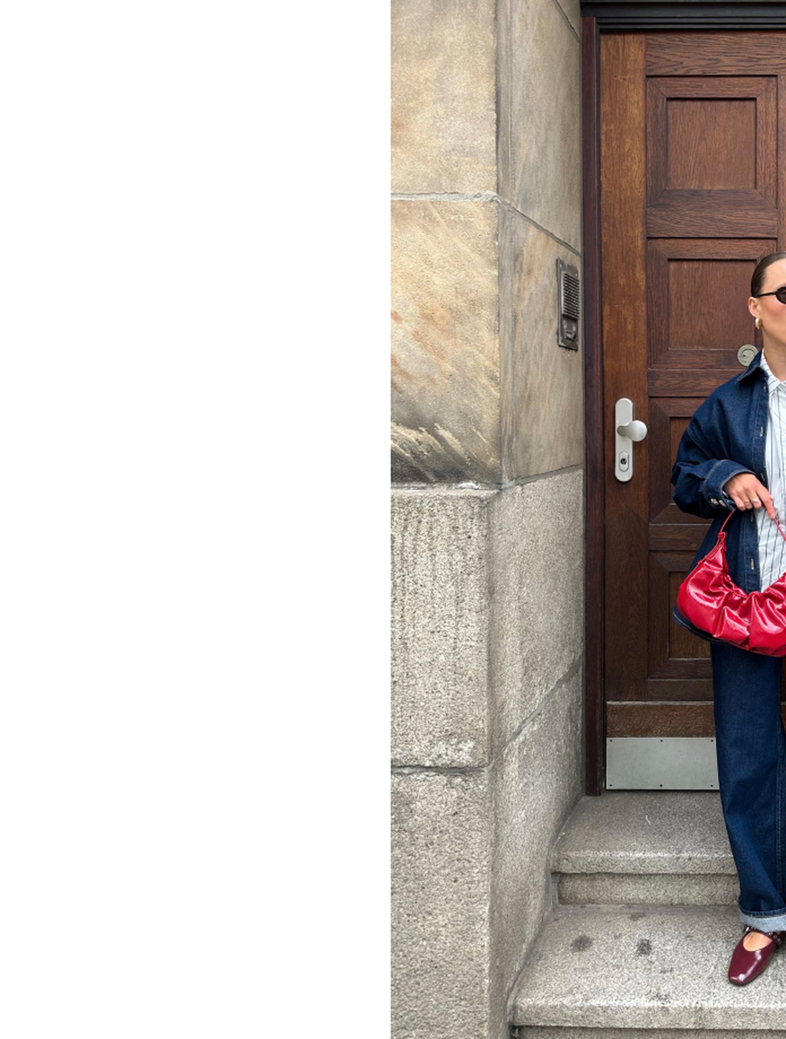 Person in denim outfit and sunglasses holding a red bag, standing by a wooden door on stone steps.