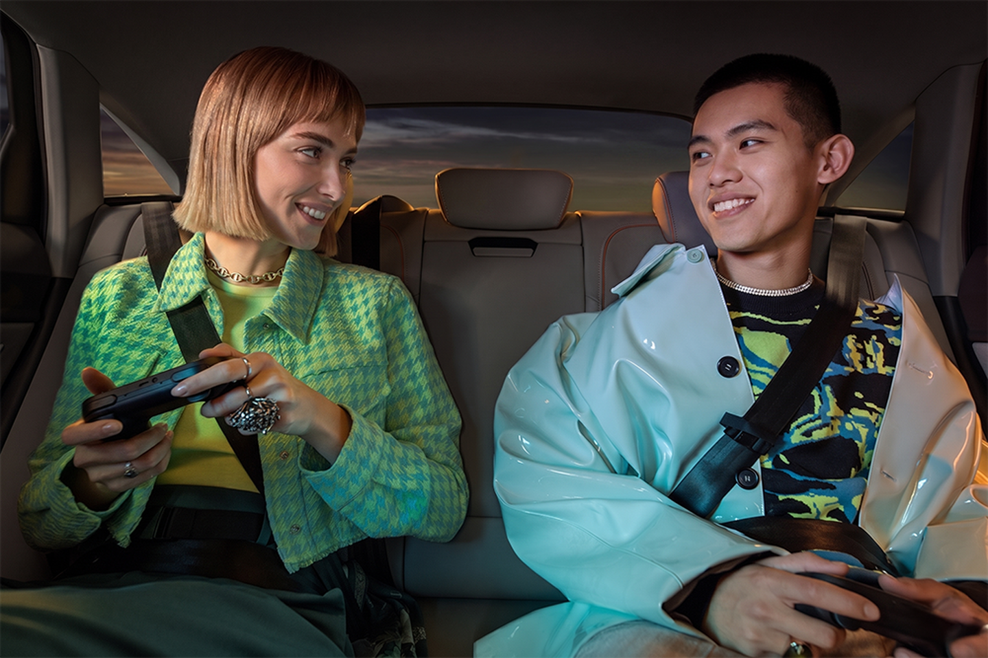 girl and boy in the backseat with headsets on and gamepads playing