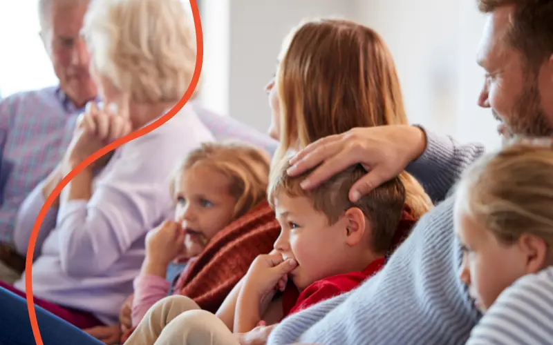 Familie sidder sammen i sofaen