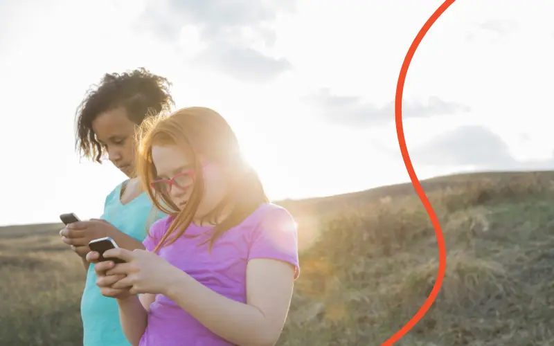 To børn spiller på deres mobiltelefoner