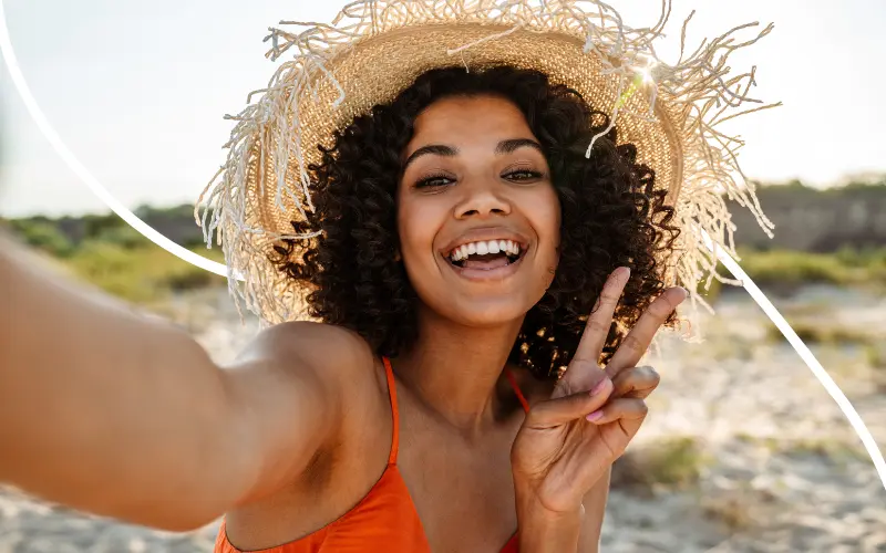Kvinde tager selfie p&aring; stranden