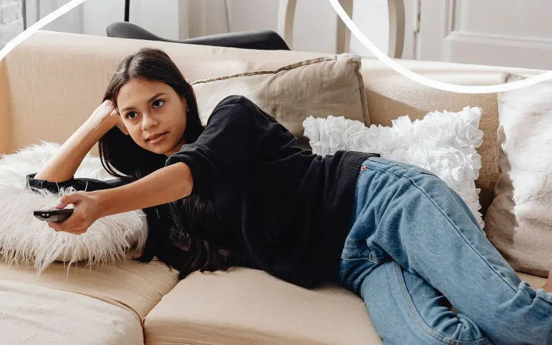 Kvinde ser sin tv-pakke p&aring; sofaen