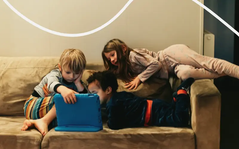 Børn ser film i sofaen på tablet