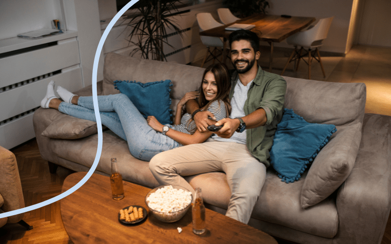 Ungt par ser film p&aring; p&aring; sofaen