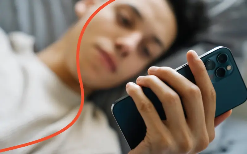Mand ligger og scroller på sin mobil