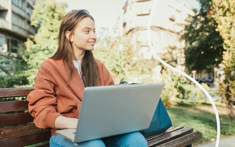 Kvinde arbejder p&aring; laptop udenfor