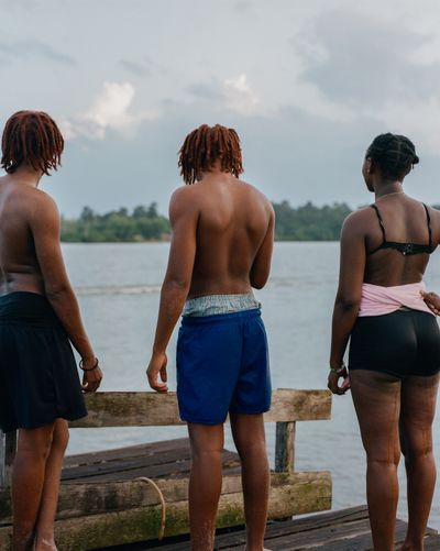 3 people standing across the water