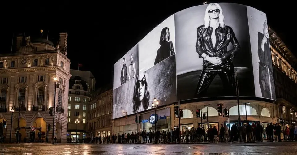 A large curved advertising screen lit up at night in a city square