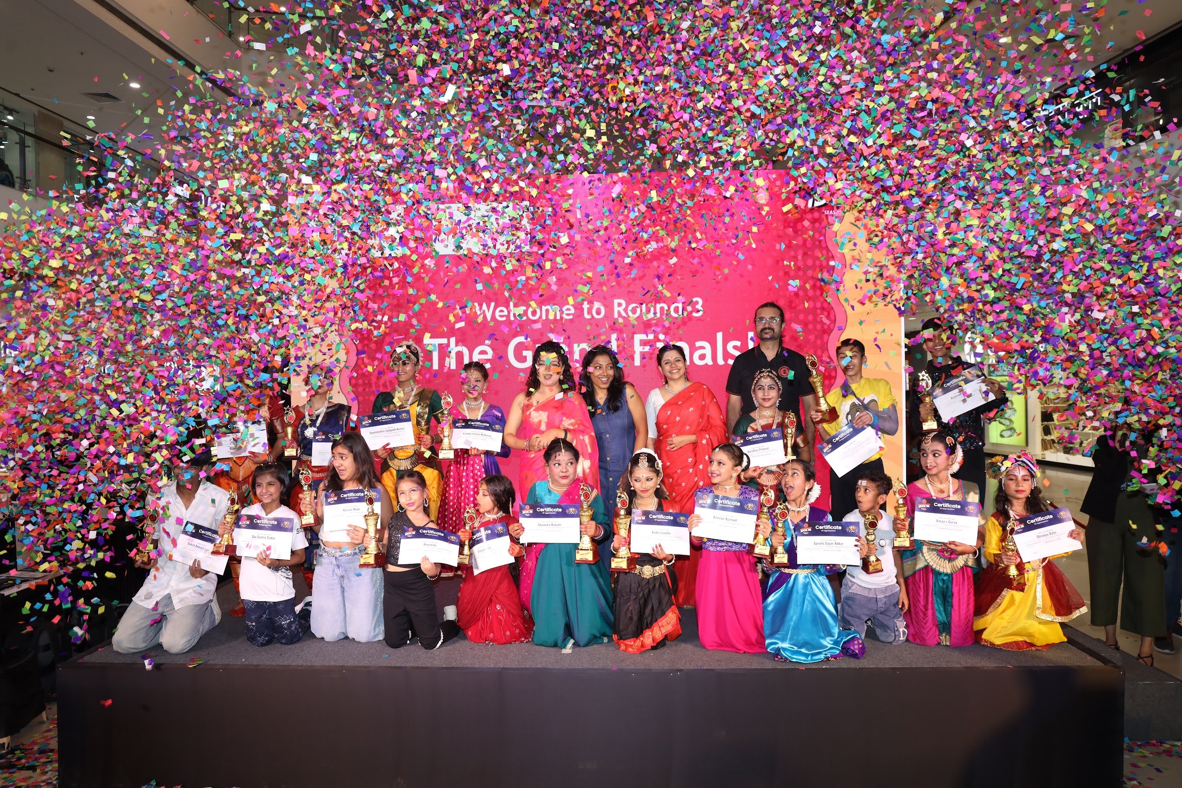 Dance category winners posing with trophies and certificates under confetti