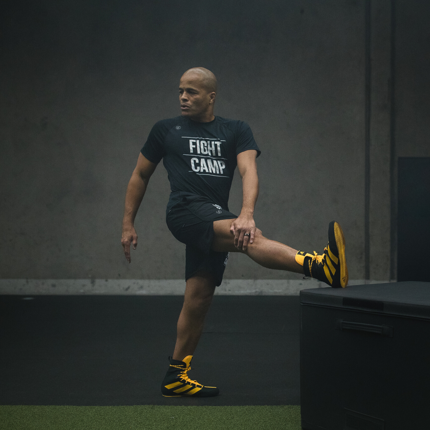 Flo Master doing a standing hamstring stretch with a torso twist
