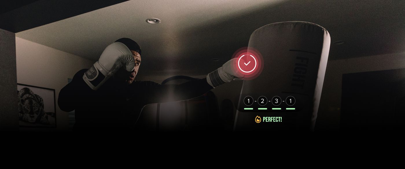 Person in boxing gloves punching a target with a digital score display showing "Perfect!" under numbered steps, in a dimly lit room.