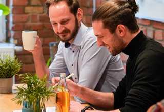 Symbolbild für Online-Marktplätze, zwei Männer, die am Schreibtisch arbeiten