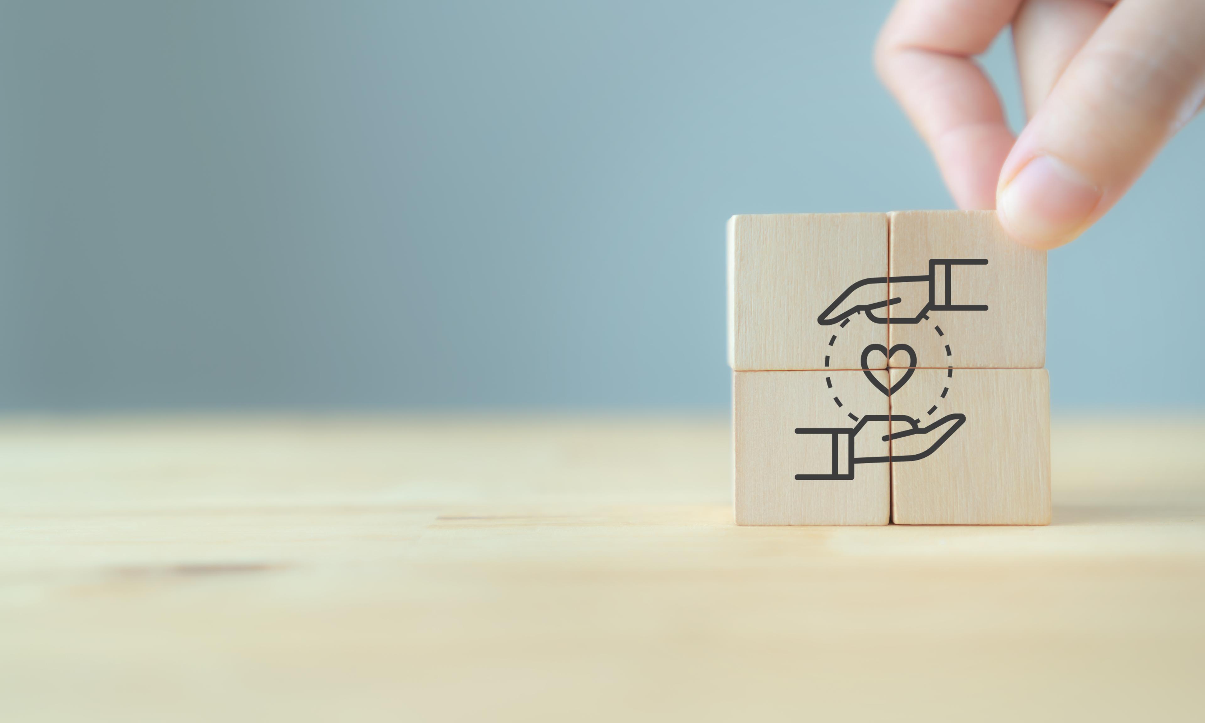 Four wooden blocks with drawing of heart and hands 