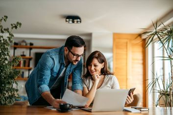 A young couple doing their finances on the laptop in their living room