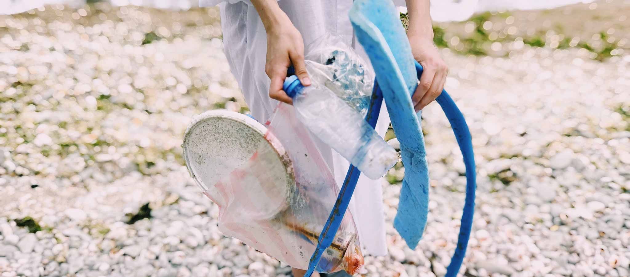 frau sammelt plastik am meer strand