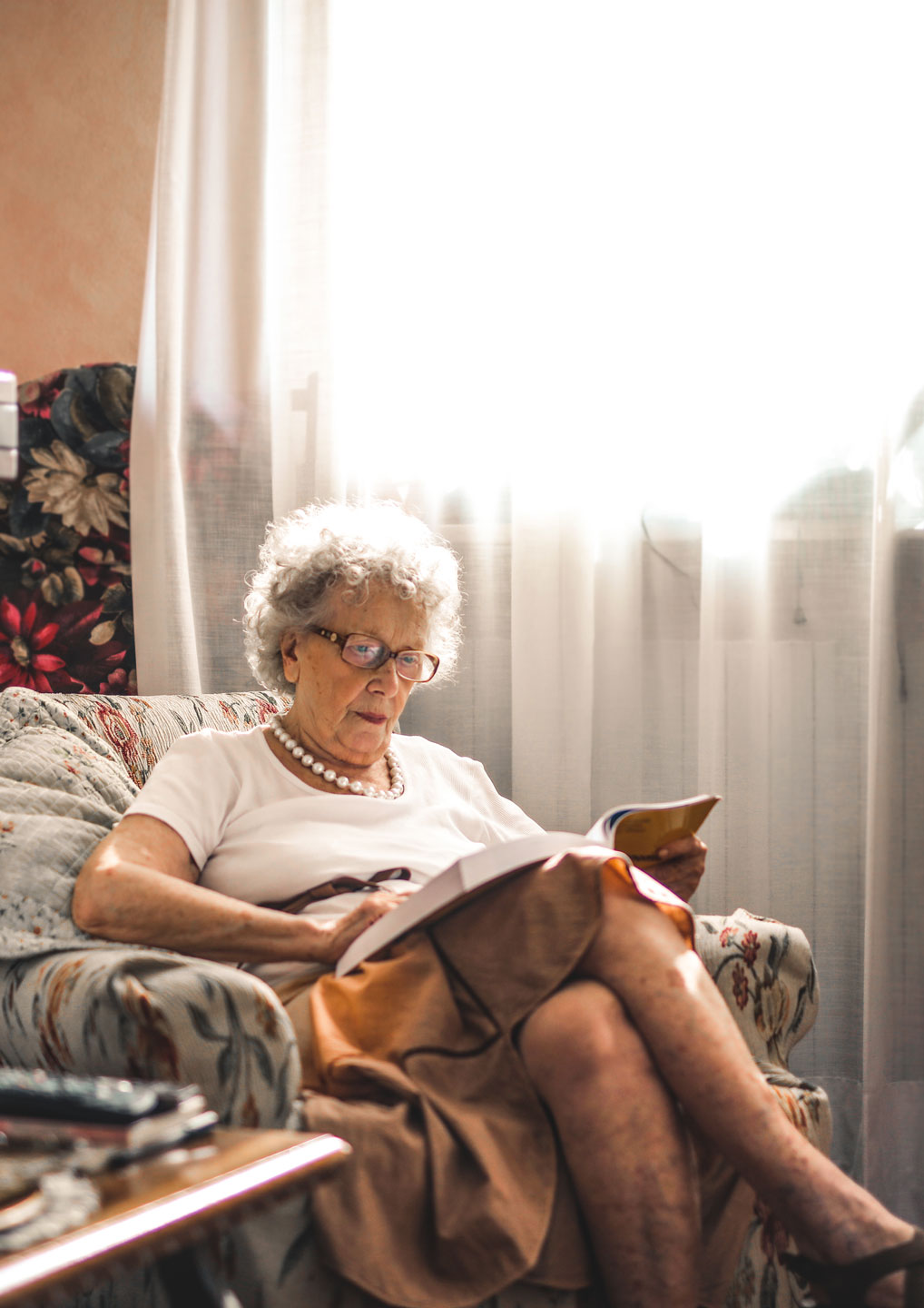 Senior woman sitting in chair reading a book